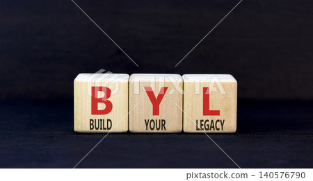 BYL build your legacy symbol. Concept words BYL build your legacy on beautiful wooden blocks. Beautiful black background. Business BYL build your legacy concept. Copy space BYL build your legacy symbol. Concept words BYL build your legacy on beautiful wooden blocks. Beautiful black background. Business BYL build your legacy concept. Copy space 140576790