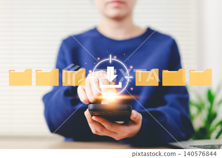 File Download and Data Transfer Concept. Woman tap download icon on smartphone with folder icons, symbolizing document file downloading, data management, and cloud technology on mobile devices. File Download and Data Transfer Concept. Woman tap download icon on smartphone with folder icons, symbolizing document file downloading, data management, and cloud technology on mobile devices. 140576844