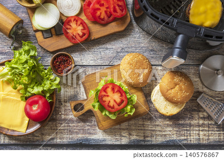 Step 12. Cooking homemade cheeseburger in kitchen gadget modern air fryer. Lifestyle trendy of new cooking. Step 12. Cooking homemade cheeseburger in kitchen gadget modern air fryer. Lifestyle trendy of new cooking. 140576867