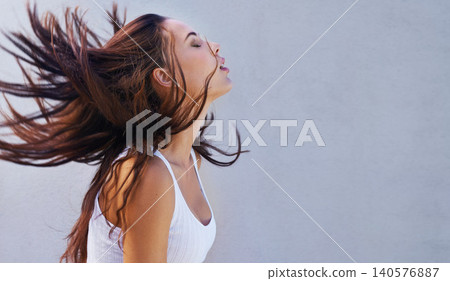Woman, hair or wind as hairdressing, hairstyle or promo of healthy, texture or growth for scalp. Shake, long or natural style as grooming in maintenance, shine or volume in studio on grey background Woman, hair or wind as hairdressing, hairstyle or promo of healthy, texture or growth for scalp. Shake, long or natural style as grooming in maintenance, shine or volume in studio on grey background 140576887
