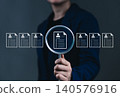 Resume Screening and Candidate Evaluation Concept. A person holds magnifying glass focusing on digital resume among several profiles, symbolizing resume screening and recruitment selection processes. 140576916