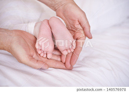 Baby, feet and hands for childcare on bed or development with parenting trust with support, love or connection. Kid, foot and fingers in palm for wellness bonding in apartment, protection or security Baby, feet and hands for childcare on bed or development with parenting trust with support, love or connection. Kid, foot and fingers in palm for wellness bonding in apartment, protection or security 140576978