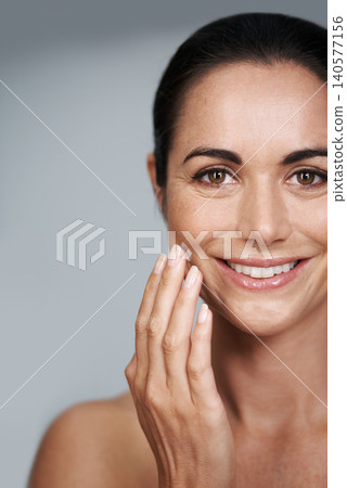 Smile, face cream and portrait of woman in studio with beauty, natural and anti aging routine. Happy, cosmetic and mature person with spf, lotion or sunscreen for dermatology by gray background. Smile, face cream and portrait of woman in studio with beauty, natural and anti aging routine. Happy, cosmetic and mature person with spf, lotion or sunscreen for dermatology by gray background. 140577156