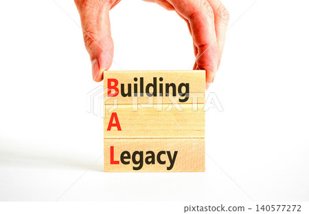 BAL building a legacy symbol. Concept words BAL building a legacy on beautiful wooden blocks. Beautiful white background. Businessman hand. Business BAL building a legacy concept. Copy space. 140577272
