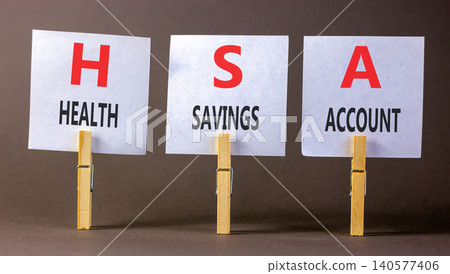 HSA health saving account symbol. Concept words HSA health saving account on beautiful white papers on clothespins. Beautiful grey background. Medical HSA health saving account concept. Copy space. 140577406