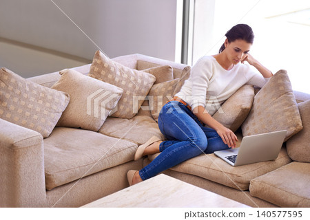 Home, relax and woman on couch with laptop for remote work, internet search or website subscription. Computer, online streaming and freelance girl on luxury sofa checking social media in living room 140577595