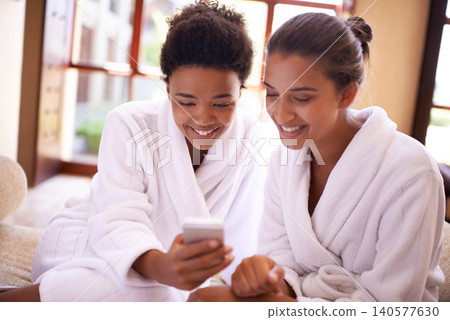 Beauty, phone and spa with woman friends in robes for luxury pampering or treatment together. Smile, app and social media with happy young people at resort or salon for wellness or weekend getaway Beauty, phone and spa with woman friends in robes for luxury pampering or treatment together. Smile, app and social media with happy young people at resort or salon for wellness or weekend getaway 140577630