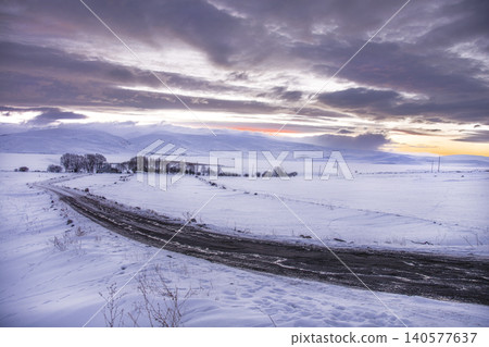 Snow covered dirt road leading to a remote village in Ardahan at sunset, Turkey Snow covered dirt road leading to a remote village in Ardahan at sunset, Turkey 140577637