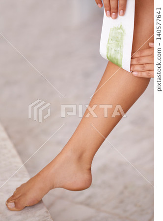 Closeup, leg and woman with waxing, luxury and wellness with dermatology and pamper in a bathroom. Person, lady and girl with hair removal and cosmetics with skincare and smooth with healthy skin 140577641