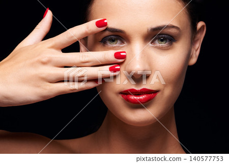 Manicure, red lips and portrait of woman in studio with makeup, trendy and beauty face routine. Nail polish, hand and young female person with facial cosmetics treatment isolated by black background. Manicure, red lips and portrait of woman in studio with makeup, trendy and beauty face routine. Nail polish, hand and young female person with facial cosmetics treatment isolated by black background. 140577753