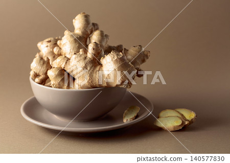 Ginger root on a beige background. Ginger root on a beige background. 140577830