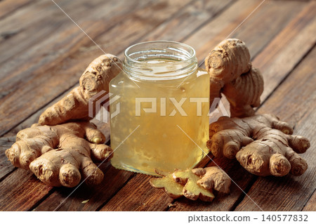 Ginger jam in jar and fresh ginger roots. Ginger jam in jar and fresh ginger roots. 140577832
