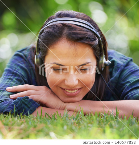Park, grass and woman with headphones, listening to music and streaming podcast with peace, relax and sunshine. Person in a backyard, outdoor or girl with headset or audio with radio, summer or sound Park, grass and woman with headphones, listening to music and streaming podcast with peace, relax and sunshine. Person in a backyard, outdoor or girl with headset or audio with radio, summer or sound 140577858