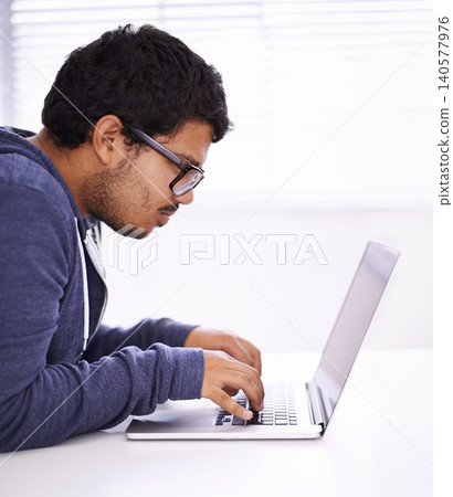 University, focus and man typing with laptop for research, study or elearning for education, knowledge and opportunity. Computer, reading and college student writing for online course with glasses. University, focus and man typing with laptop for research, study or elearning for education, knowledge and opportunity. Computer, reading and college student writing for online course with glasses. 140577976