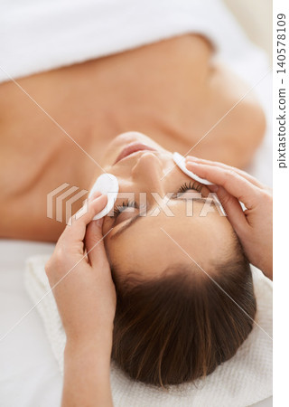 Woman, pad and facial massage for cosmetics treatment to relax, cleaning and beauty therapy for skin care. Female person, calm and serene or dermatology, closeup and rest at hotel and peace or zen Woman, pad and facial massage for cosmetics treatment to relax, cleaning and beauty therapy for skin care. Female person, calm and serene or dermatology, closeup and rest at hotel and peace or zen 140578109