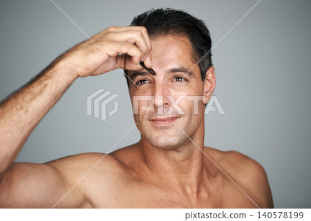 Man, eyebrows and tweezers for hair removal in studio for grooming treatment, maintenance or grey background. Male person, hand and tool for skincare transformation or wellness, self care or mockup Man, eyebrows and tweezers for hair removal in studio for grooming treatment, maintenance or grey background. Male person, hand and tool for skincare transformation or wellness, self care or mockup 140578199