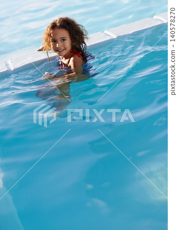 Child, girl and water with face, swimwear and blue summer sky for relax and smile. Kid, pool and sunshine with happiness, outdoor and play with curly hair and fun for sunny positivity and childhood Child, girl and water with face, swimwear and blue summer sky for relax and smile. Kid, pool and sunshine with happiness, outdoor and play with curly hair and fun for sunny positivity and childhood 140578270