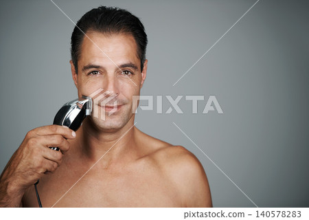 Man, portrait and razor for shaving or grooming skincare for electric tool or dermatology, trimmer or grey background. Male person, face and hair removal for beard routine, mockup space or studio Man, portrait and razor for shaving or grooming skincare for electric tool or dermatology, trimmer or grey background. Male person, face and hair removal for beard routine, mockup space or studio 140578283