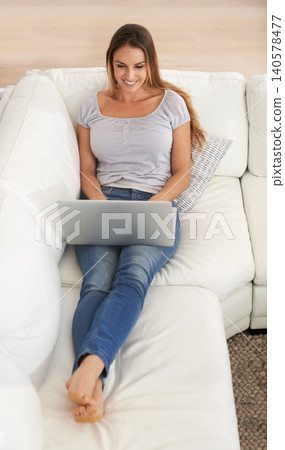 Woman, smile or laptop on sofa to search, internet or email in digital, communication or news. Happy, female person or computer as writing, reading or blog to download online game, meme or ebook Woman, smile or laptop on sofa to search, internet or email in digital, communication or news. Happy, female person or computer as writing, reading or blog to download online game, meme or ebook 140578477
