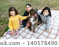 Children Relaxing with Their Dog on a Picnic Blanket in the Park 140578490