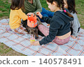 Children Celebrating Dog Birthday Picnic Outdoors with Homemade Crown and Cake 140578491