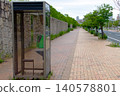 A Japanese urban landscape featuring sidewalks and public telephones. 140578801