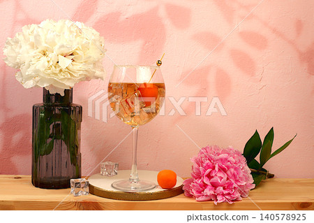 Royal lemonade cocktail with tequila, gin, rum, ice and fresh apricot berries, bar and party concept with peonies, restaurant and cafe advertising card, minimal still life with flowers and alcohol, 140578925