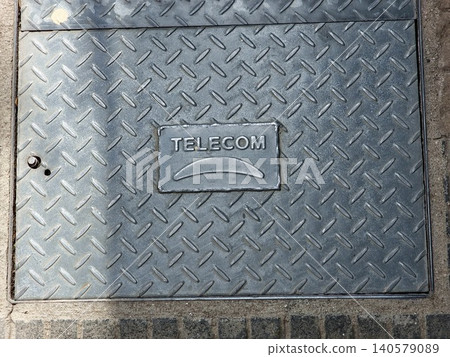 Cordoba, Argentina - April 9, 2026: Telecom utility manhole cover installed in a city sidewalk in Cordoba Cordoba, Argentina - April 9, 2026: Telecom utility manhole cover installed in a city sidewalk in Cordoba 140579089