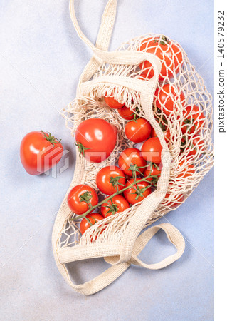 Fresh organic tomatoes in reusable mesh net bag 140579232