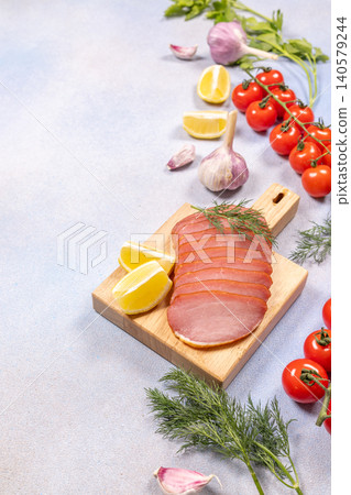Sliced smoked meat appetizer with lemon and fresh ingredients Sliced smoked meat appetizer with lemon and fresh ingredients 140579244