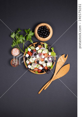 Fresh greek salad in wooden bowl on dark background Fresh greek salad in wooden bowl on dark background 140579281