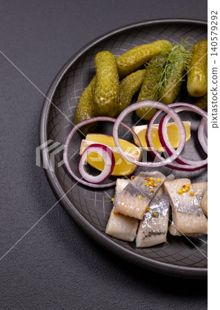 Pickled herring fillets with gherkins and red onion rings Pickled herring fillets with gherkins and red onion rings 140579292