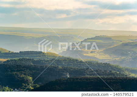 Layers of green mountains and hills in the haze during sunset. Panoramic View of Green hills and Meadow. Layers of green mountains and hills in the haze during sunset. Panoramic View of Green hills and Meadow. 140579521