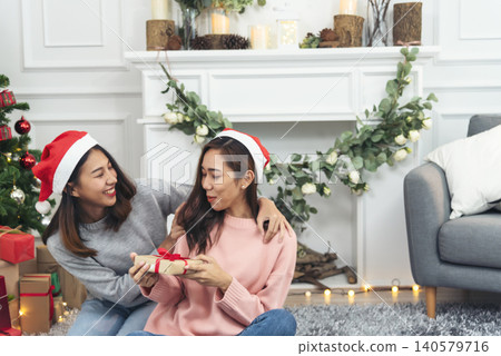 Two Women siblings using hands decorate Christmas tree red ball, bauble, snow flake. Close up hands holding red ball bauble decorate. Asian woman friends decor bauble ball christmas tree xmas holiday Two Women siblings using hands decorate Christmas tree red ball, bauble, snow flake. Close up hands holding red ball bauble decorate. Asian woman friends decor bauble ball christmas tree xmas holiday 140579716