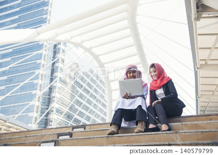 Arab team hold digital tablet uae union teamwork people. Digital marketing arab group of people using smart tablet discuss modern muslim UAE city. Entrepreneur Asian people smile teams meeting. Arab team hold digital tablet uae union teamwork people. Digital marketing arab group of people using smart tablet discuss modern muslim UAE city. Entrepreneur Asian people smile teams meeting. 140579799