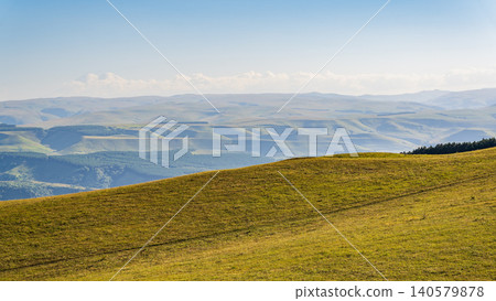 Layers of green mountains and hills in the haze during sunset. Panoramic View of Green hills and Meadow. Layers of green mountains and hills in the haze during sunset. Panoramic View of Green hills and Meadow. 140579878