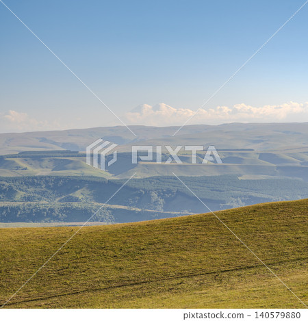 Panoramic view of the green valley and the snowy peak of Mount Elbrus on the horizon against the blue sky on a sunny clear morning in Kislovodsk Stavropol territory, Russia 140579880