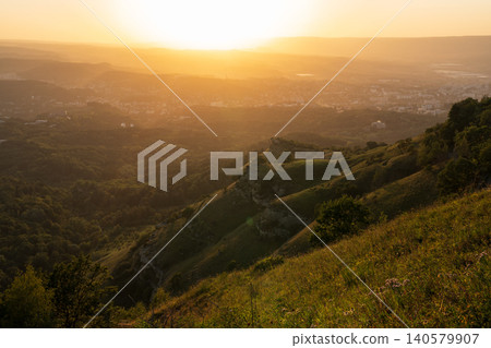 View of the mountains and Kislovodsk from the observation decks of the Kislovodsk Park. Evening sunset over the mountains of Kislovodsk. View of the mountains and Kislovodsk from the observation decks of the Kislovodsk Park. Evening sunset over the mountains of Kislovodsk. 140579907