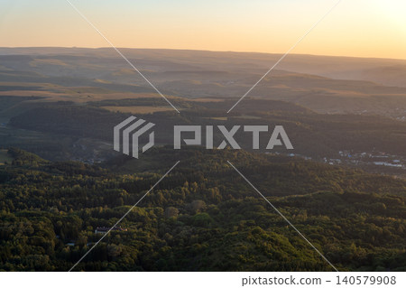 Layers of green mountains and hills in the haze during sunset. Panoramic View of Green hills and Meadow. 140579908