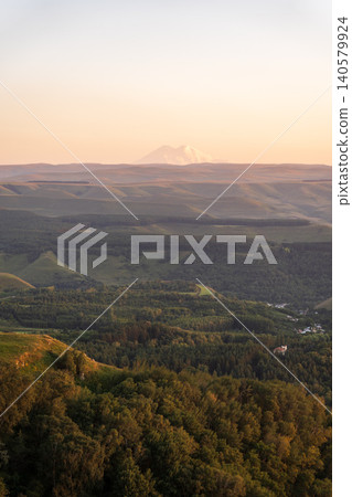 Layers of green mountains and hills in the haze during sunset. Panoramic View of Green hills and Meadow. Layers of green mountains and hills in the haze during sunset. Panoramic View of Green hills and Meadow. 140579924