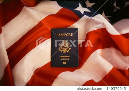 United States passport placed on American flag background, showcasing the emblem and text, symbolizing travel and national identity United States passport placed on American flag background, showcasing the emblem and text, symbolizing travel and national identity 140579945