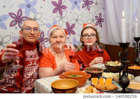family celebrates new year and christmas at a festive table with wine glasses 140580259