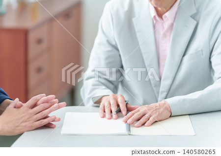 An elderly man writing in a notebook. An elderly man writing in a notebook. 140580265