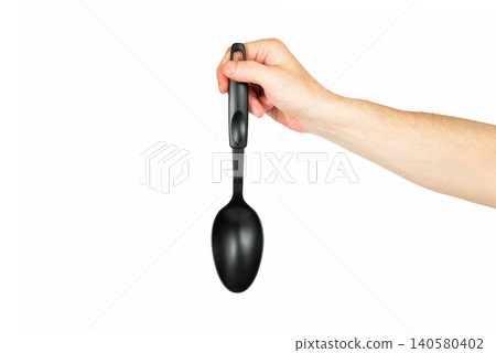 black plastic kitchen spoon vertically in a hand on a white background black plastic kitchen spoon vertically in a hand on a white background 140580402