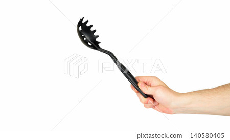 black plastic spaghetti spoon in hand diagonally black plastic spaghetti spoon in hand diagonally 140580405