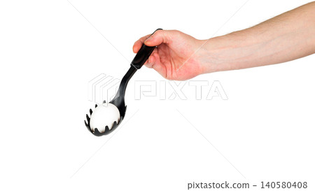 chicken egg in a black pasta spoon on a white background 140580408