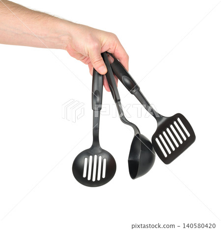 person retains three black kitchen appliances in a hand on a white background person retains three black kitchen appliances in a hand on a white background 140580420