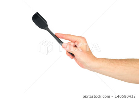 a male hand pointing a black kitchen spatula upward at an angle on a white background a male hand pointing a black kitchen spatula upward at an angle on a white background 140580432