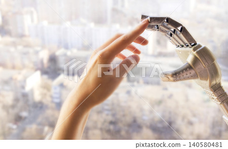 Human hand reaching towards a robotic prosthetic hand in a bright urban setting, showcasing advanced technology and innovation in assistive devices Human hand reaching towards a robotic prosthetic hand in a bright urban setting, showcasing advanced technology and innovation in assistive devices 140580481