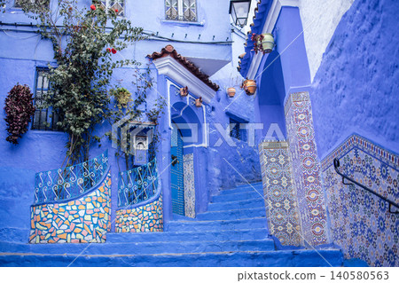 Vibrant blue staircase adorned with intricate tile patterns and lush greenery, leading to a charming doorway, showcasing the beauty of traditional architecture and cultural heritage Vibrant blue staircase adorned with intricate tile patterns and lush greenery, leading to a charming doorway, showcasing the beauty of traditional architecture and cultural heritage 140580563